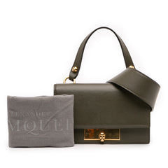 Alexander McQueen mini leather skull lock top handle bag in green, featuring a distinctive skull detail and compact design.