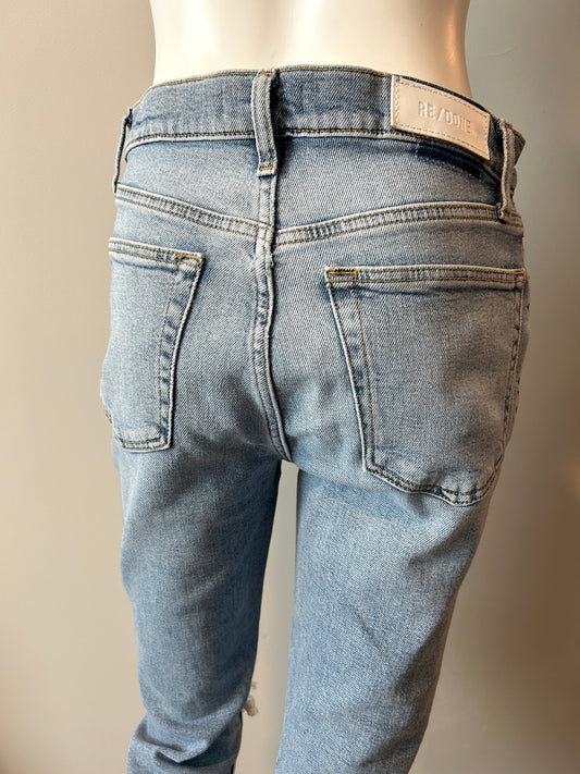 Re/Done 90s high rise ankle crop jeans in size 28, showcasing distressed denim and classic fit on a hanger.