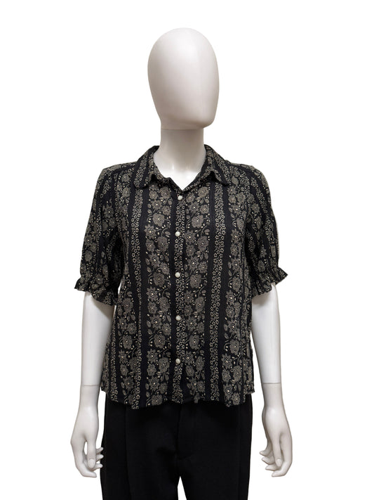 The Great cotton blouse showcased on a hanger, featuring a classic design with long sleeves and a button-up front.