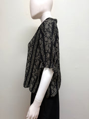 Light blue The Great Cotton Blouse with long sleeves and a relaxed fit, displayed on a hanger.