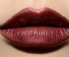 Chanel Rouge Allure Laque lipstick in Fancy Prune shade, featuring smooth, glossy lips with rich plum color.