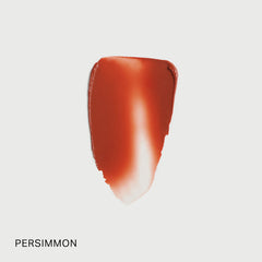 Merit Flush Balm Cream Blush in Persimmon shade, natural-looking beauty blush with smooth texture and vibrant color on skin.