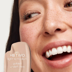 Saie Hydrabeam under eye brightener in various shades, featuring a sleek applicator and hydrating concealer for a luminous look.