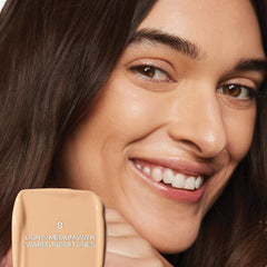 Saie Slip Tint Radiant All-Over Concealer in various shades, featuring a sleek tube and applicator for natural skin tone coverage.