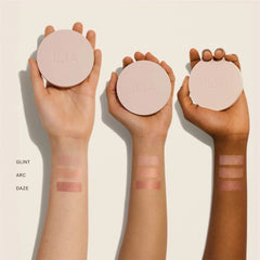 Ilia Lightshift Weightless Silky Cream Highlighter in a shade, smooth texture, highlighting the cheekbone area with a compact container